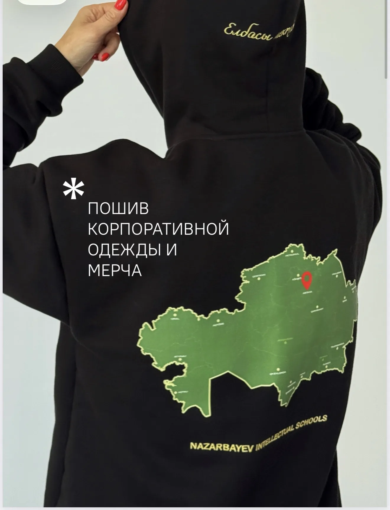 Фирмалық жилет киген фабрика қызметкері кестелеу машиналарының жанында
